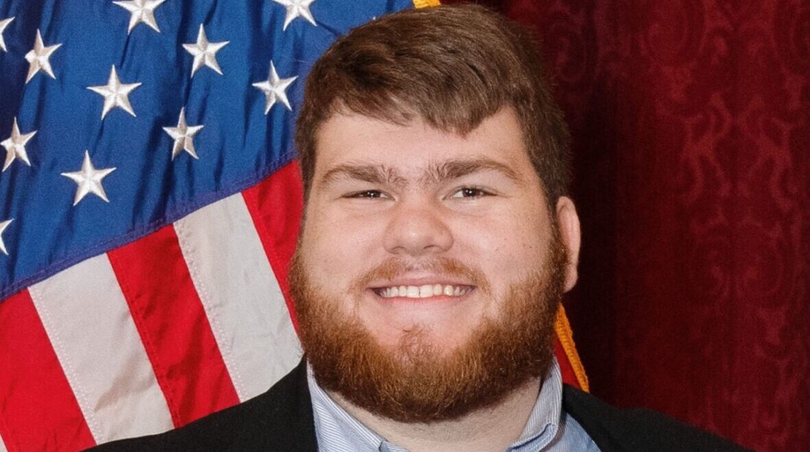 Trenton Hale, author of three liberty-related books, poses in front of the American flag.